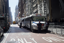 Four NYPD buses parked next to crowd control fences