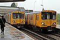 Merseyrail Class 507 and Class 508 units pass at the station.