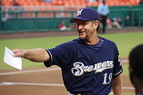 A man in a navy blue baseball jersey with "Brewers" written across the chest