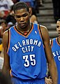 A basketball player, wearing a light blue jersey with the words "OKLAHOMA" and "CITY" and the number 35 on the front, stands on a basketball court.