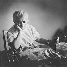 A black and white photograph of Dr. Gheorghiu sitting with some medical equipment on the table in front of her