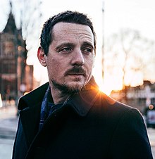 A head shot of singer Sturgill Simpson, in an outdoor setting