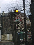 A traffic signal ahead sign in France (The light flashes to indicate a red light ahead.)