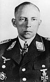 Black-and-white photo of a man wearing military uniform with various military decorations including an Iron Cross at his neck.