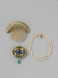 A decorative gold haircomb, gold pin decorated with jewels, and a multi-strand pearl necklace with gold accents.