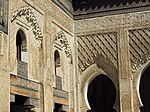 Stucco carving, including muqarnas, along the walls and arches of the courtyard