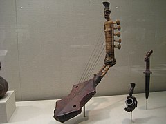 Harpe cintrée à 5 cordes ornée d'une figure anthropomorphe[27].