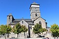 Vue latérale de l'église dominée par son imposant clocher-tour qui s'élève à la verticale de la croisée du transept