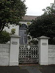 Free-standing single stately house now subdivided into smaller units; low pitched full hipped welsh slate roof; possibly original sash windows (24 panes); double leafed panelled door with unsuitable modern 'period' timber door surround; raised open stoep Type of site: House Current use: House.