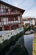 Reflet de maisons dans un cours d’eau.