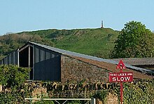 Triangular shaped building made of corrugated iron and stone.