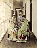 1885 hand-coloured albumen silver print by Farsari of three Maiko posing on an engawa