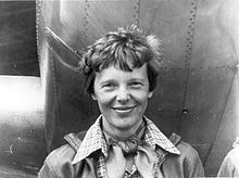 Amelia Earhart standing next to her aircraft