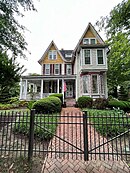 two and a half-story house with large porch and irregular roof line