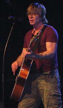 Rzeznik onstage, playing an acoustic guitar