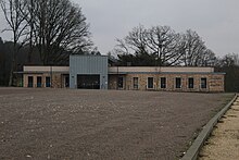 Au second plan la maison de santé de Saint-Sauveur-en-Puisaye. Un long bâtiment d'un seul niveau avec de nombreuses fenêtres. Au premier plan un parking vide.