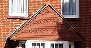 Red brick and tile-hung detail, "a little genuine Queen Anne"[4]