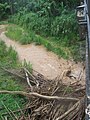 Río Culebrinas collecting debris at bottom of slanted bridge between Magos barrio and Calabazas barrio