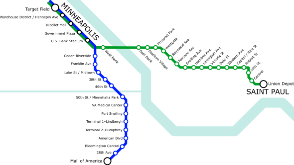 A simple transit diagram with a green line stretching roughly left to right (west to east) and a blue line stretching roughly top to bottom (north to south). A light blue river runs from the top right to the bottom right, roughly following the shape of a ladle. Another thinner waterway runs straight from center-left to connect with the river near the center of the image.