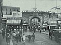 Vue de la porte entourée de boutiques en 1895.