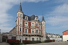 Photographie en couleur d'un château en briques rouges et en tuffeau blanc.