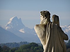 Vue sur une montagne enneigée avec une statue en premier plan.