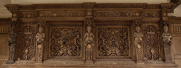 and a carved fireplace with male and female figures, interspersed with grotesque heads.