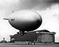 A 1943 photo of a Navy 'K' type blimp in front of one of MCAS Tustin's massive blimp hangars.