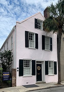 Color photograph of two Charleston single houses, on the left is 14 Queen Street, a light purple painted house