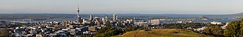 Horizonte a cidade de Auckland. Em primeiro plano se vê uma parte do Mount Eden. À esquerda, no fundo, a ponte do porto de Auckland. Auckland é uma grande cidade metropolitana na Ilha Norte da Nova Zelândia. A área urbana mais populosa do país e a quinta maior cidade da Oceania. Enquanto os europeus continuam a constituir a pluralidade da população de Auckland, a cidade tornou-se multicultural e cosmopolita no final do século XX, com os asiáticos respondendo por 31% da população da cidade em 2018. O nome da língua maori para Auckland é Tāmaki Makaurau, que significa “Tāmaki desejado por muitos”, em referência à conveniência de seus recursos naturais e geografia. (definição 2 560 × 388)