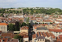 Photographie des toits de la ville au premier plan et des immeubles en arrière-plan.