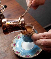 Turkish coffee being poured into a small cup