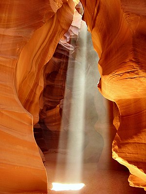 קרן אור חודרת בין הקירות העשויים אבן גיר של קניון אנטילופ באריזונה