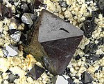 Octahedral crystals of magnetite up to 1.8 cm across, on cream colored feldspar crystals, locality: Cerro Huañaquino, Potosí Department, Bolivia