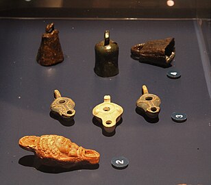 Objets d'ambiance mis au jour dans des mithréums : lampes à huile (Güglingen, Angers) et clochettes en fer (Mandelieu-La Napoule).