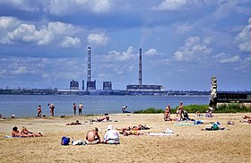 Praia em Svitlodarsk com a Usina de Vuhlehirska ao fundo.