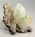 Stilbite crystals surround a pastel green, translucent fluorapophyllite crystal