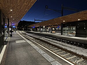 Platform with wooden roof next to some railway tracks