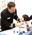 A male nurse at a hospital of the US Navy attends to a child