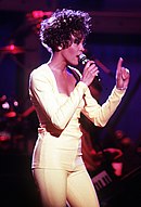 Whitney Houston singing with a mic in her hand.