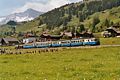 Metre-gauge electric twin motor coach ABDe 8/8 4004 of the Montreux–Lenk im Simmental line in Switzerland pulling two coaches and two cement wagons