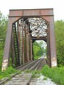 Ouvrage d'art pour une voie unique. Les rails posées au centre de la voie servent de renforts au niveau du platelage du pont.