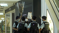 A woman holding a white paper and a cross was surrounded by police officers in Fashion Walk.