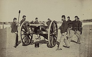 Sepia photo shows a Civil War era USA gun crew practicing with a 20-pounder Parrott rifled gun.