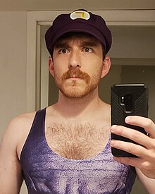 A photo of Wreden wearing a swimsuit and Waluigi hat