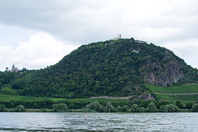 Le Drachenfels vu depuis le Rhin avec les ruines du château Drachenfels à son sommet et le château de Drachenburg sur la gauche.