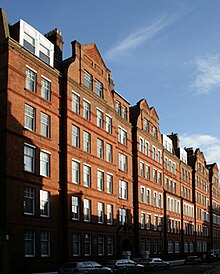 D'élégantes façades d'immeubles en briques rouges, avec de nombreuses fenêtres.