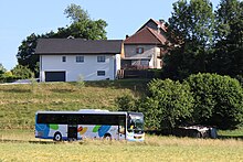 Photographie en couleurs d’un car aux couleurs Sibra arrivant à Rumilly en mai 2022.