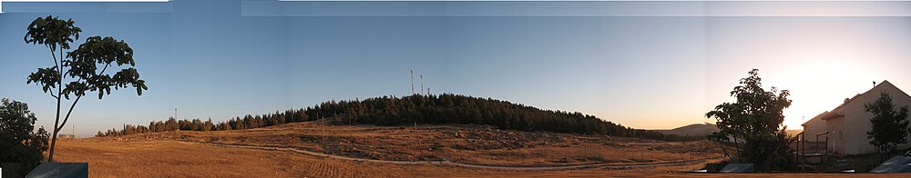 תמונה פנורמית של תל א-תוואני – מצולם ממעון. בשני צידי התמונה בתים במעון.