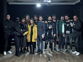 From left to right, standing together, Hossein Abedini, Zoha Mousavi, Kosar Eftekhari, Mohammad Farzi, Ali Tahoune, Yaser Alvandiani, Mohsen Kafshegar and Ali Mohammadi, gathered together with other members of the group.